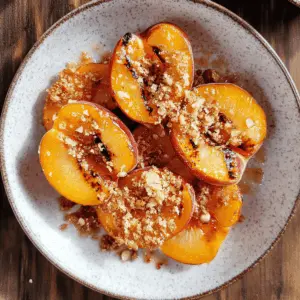 Sweet, juicy grilled peaches meet crunchy almond cookie crumbs in this delightful recipe! Perfect for summer gatherings or a cozy night in, these maple-infused peaches add a touch of elegance to any dish. Save this easy recipe to impress friends and family at your next barbecue or dessert night!